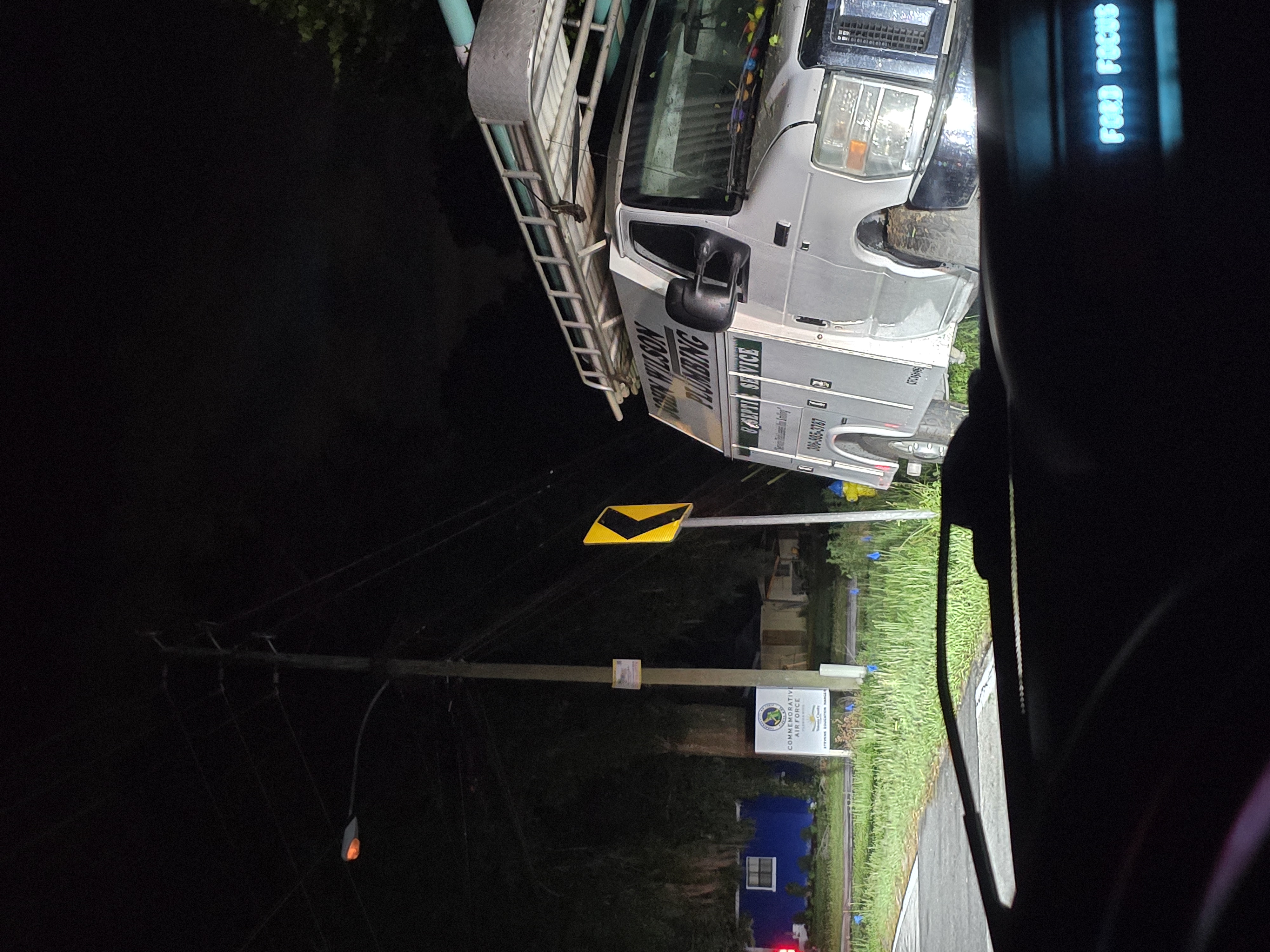 Close view of run-off-road service vehicle next to curve sign